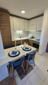 a kitchen with a table with two chairs and a counter at Panorama Apartment in Mavrovo