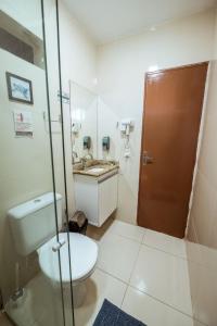a bathroom with a toilet and a sink at Casa em Jacumã com Piscina, 5 Suítes e Fliperama in Conde +32 photos
