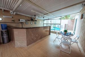 a kitchen with a table and chairs in a room at Casa em Jacumã com Piscina, 5 Suítes e Fliperama in Conde