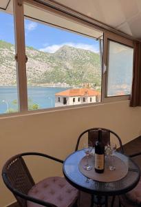 a table with two chairs and a bottle of wine at Mivasto Sea View in Risan