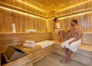 a man and a woman sitting in a sauna at CarDiem Suites in Baños