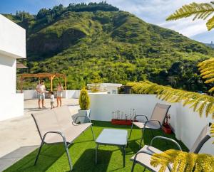 a patio with chairs and a mountain in the background at CarDiem Suites in Baños +11 photos