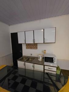 a kitchen with a sink and a microwave at Ypane Residencial in Ypane