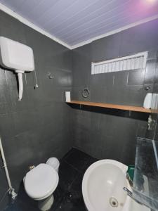 a bathroom with a white toilet and a sink at Ypane Residencial in Ypane +13 photos