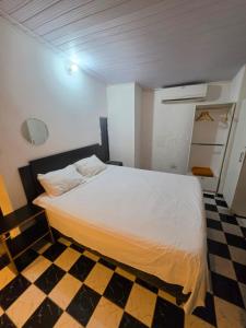 a bedroom with a white bed and a checkered floor at Ypane Residencial in Ypane
