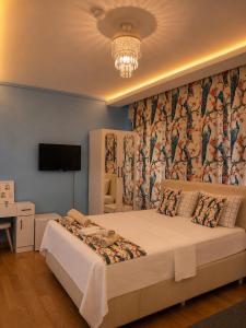a bedroom with a large bed and a chandelier at Grand Sur Butik Otel in Diyarbakır
