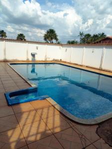 a swimming pool with blue water in a yard at Fênix Hotel Colinas do Tocantins in Colinas do Tocantins