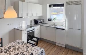 a kitchen with white cabinets and a sink and a refrigerator at Stunning Home In Ringkøbing With Wifi in Ringkøbing