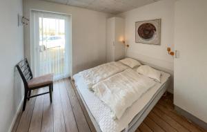 a bed in a room with a chair and a window at Stunning Home In Ringkøbing With Wifi in Ringkøbing