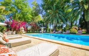 a swimming pool with chairs and palm trees at Santa Lucia in Binissalem