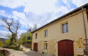 a stone house with red doors and a driveway at Mazet Du Gua in La Pervenche +8 photos