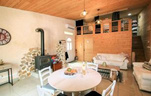a living room with a table and a stove at Mazet Du Gua in La Pervenche