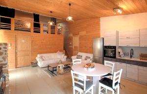 a kitchen and living room with a table and a couch at Mazet Du Gua in La Pervenche