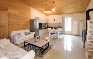 a living room with a white couch and a kitchen at Mazet Du Gua in La Pervenche