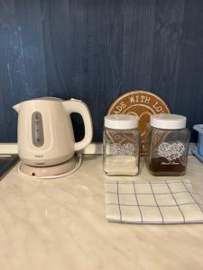 a coffee maker and two jars on a counter at Vila Simic in Soko Banja
