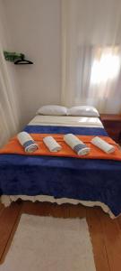 a bed with three pillows on top of it at Contos de Alice in Tiradentes