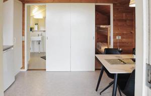a kitchen and dining room with white cabinets and a table at Lovely Apartment In Farsø in Farsø