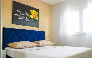 a bed with a blue headboard in a bedroom at Amazing Home In Dugobabe in Dugobabe
