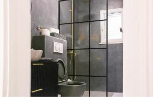 a bathroom with a toilet and a glass wall at Amazing Home In Dugobabe in Dugobabe