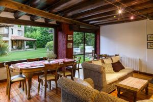 a living room with a table and chairs and a couch at Lares De Chacras in Chacras de Coria