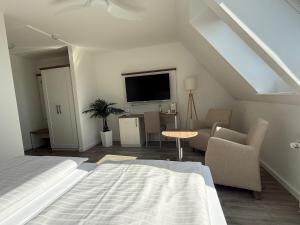 a bedroom with a bed and a living room at Alago Hotel am See in Cambs