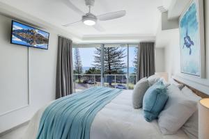 a bedroom with a large bed and a large window at Dwell @ 22, Oceanfront Apartment in Bargara +21 photos
