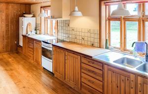 a kitchen with wooden cabinets and a white refrigerator at 3 Bedroom Stunning Home In Bedsted Thy in Bedsted Thy