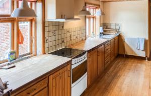 a kitchen with wooden cabinets and a stove top oven at 3 Bedroom Stunning Home In Bedsted Thy in Bedsted Thy