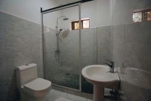 a bathroom with a shower and a toilet and a sink at Naibor Villa Arusha in Arusha