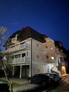 a large building with cars parked in front of it at Vila Simic in Soko Banja