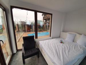 a bedroom with a bed and a chair and a window at Chalet Trushnyi in Palyanytsya +20 photos