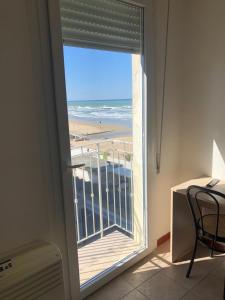 a room with a window with a view of the beach at Hotel Continental in Pesaro