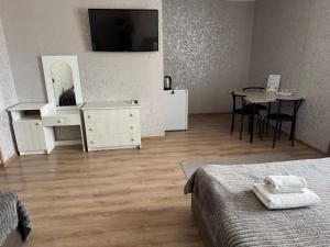 a room with two beds and a table and a television at Готель «У Батька» in Truskavets