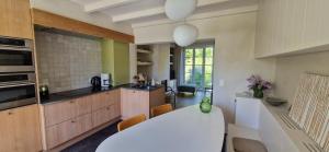 a kitchen with wooden cabinets and a white counter top at Authentiek Vakantiehuis Bos-en-Veld - Prive-tuin - Fietsvriendelijk vlakbij Brugge in Wingene