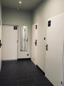a room with three doors and a tile floor at KWADRAT hostel in Roztworowo