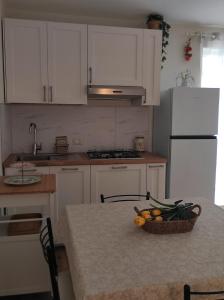 a kitchen with a table with a basket of fruit on it at Elena 's HOME in Conversano