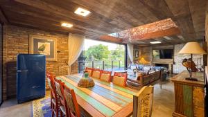 a dining room with a long wooden table and chairs at Sítio Mello in Igrejinha