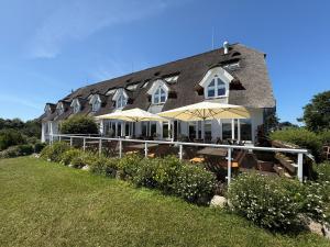 a building with tables and umbrellas in front of it at Alago Hotel am See in Cambs +41 photos