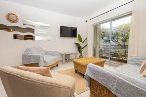 a living room with a couch and chairs and a tv at Cantinho Lusitano in Portimão