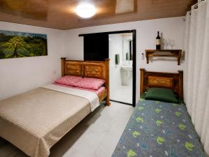 a bedroom with two beds and a bathroom at Rio Sereno Suítes Comfort - Lumiar in Lumiar