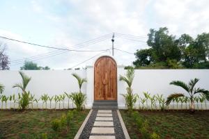 a wooden door in a white wall at Home Riki in Badung