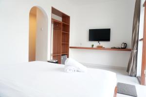 a hotel room with a bed and a tv at Home Riki in Badung