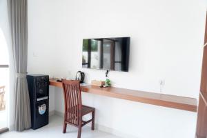 a desk with a chair and a mirror on a wall at Home Riki in Badung