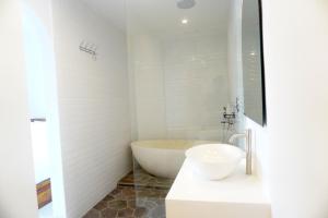 a white bathroom with a tub and a sink at Home Riki in Badung +24 photos