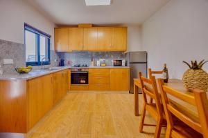 a kitchen with wooden cabinets and a table with chairs at Os Paizinhos do Arrujo in Cinfães +14 photos