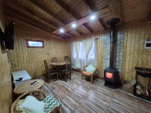a room with a stove and a table and chairs at Cabaña Nuevo Amanecer in San José de la Mariquina