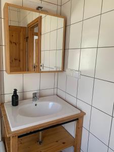a bathroom with a sink and a mirror at Ferienhaus Kobel in Stromberg +14 photos