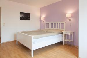 ein Schlafzimmer mit einem weißen Bett und einem Tisch in der Unterkunft Dorotheenhof in Flensburg