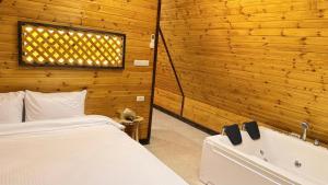 a bedroom with a bed and a bath tub at Al Joud Chalet Private Jacuzzi & BBQ Ajloun in Ajloun