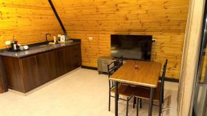 a dining room with a table and a television at Al Joud Chalet Private Jacuzzi & BBQ Ajloun in Ajloun